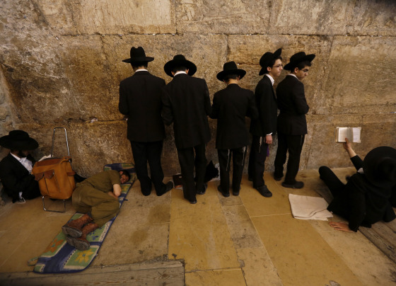 Ultra-Orthodox Jewish youths pray on Tisha B'Av at the Western Wall in Jerusalem's Old City